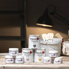 frenchic lifestyle image of tins of paint stacked on a bench
