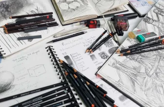 Sketching pencils in a range of graphite grades laid out on a sketchbook